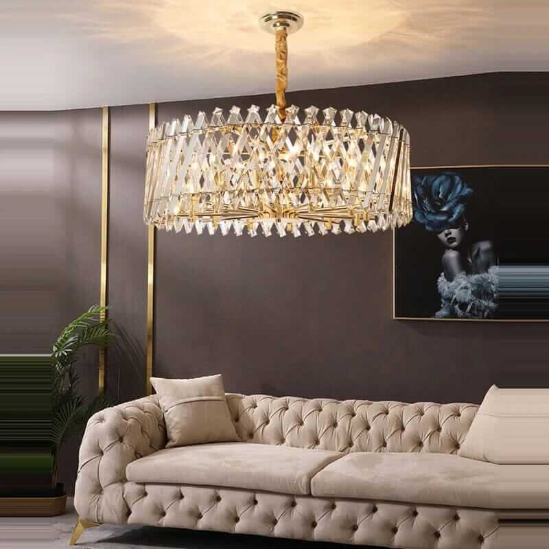 Luxurious crystal chandelier above a beige tufted sofa in a modern living room setting.