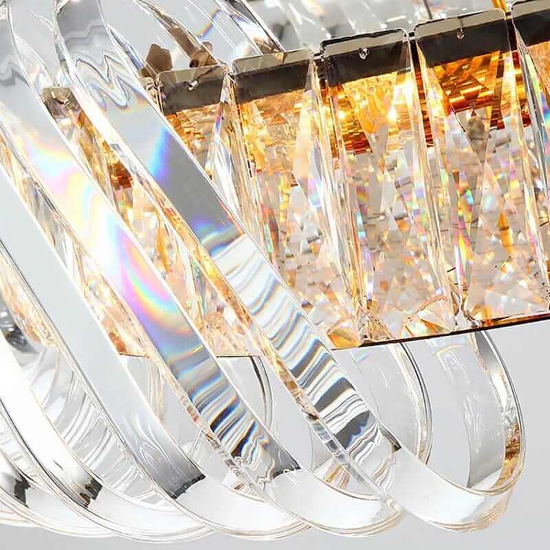 Close-up of an elegant entryway chandelier showcasing crystal details and a shimmering gold finish.
