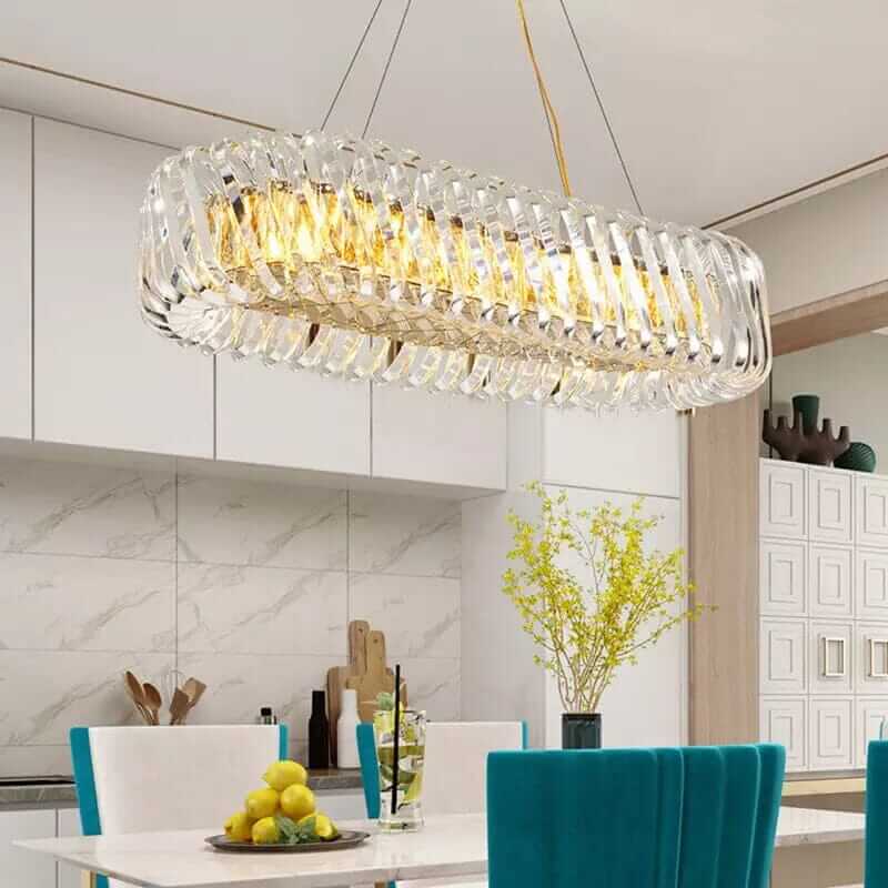 Stylish kitchen decor featuring a modern elongated chandelier with golden accents and clear glass design.