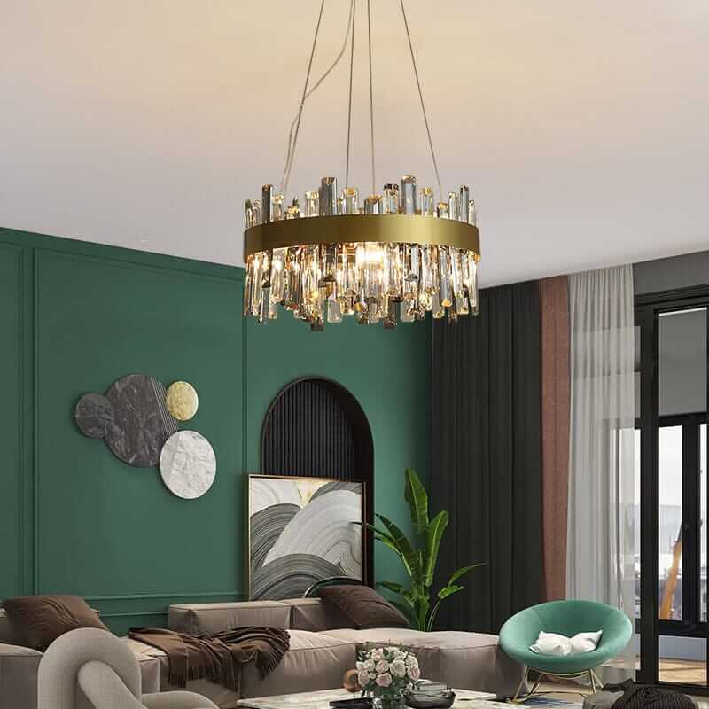 Gold crystal chandelier illuminating a modern living room with green walls and stylish furniture.