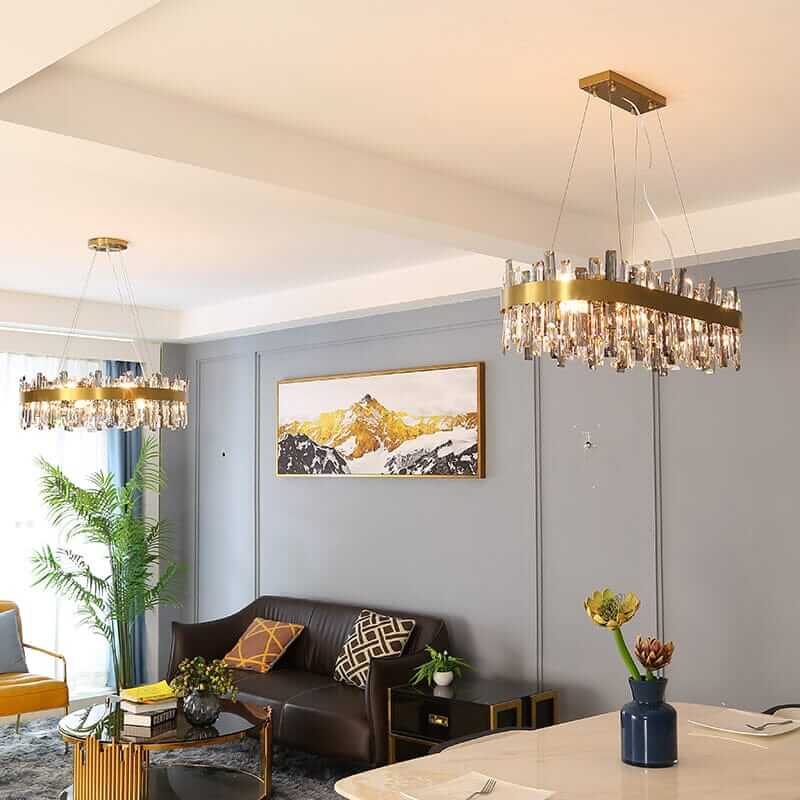 Gold crystal chandeliers illuminate a modern living room with elegant decor and stylish furnishings.