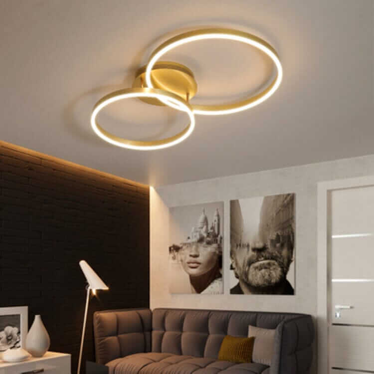 Modern LED chandelier with double circular rings illuminating a stylish living room.