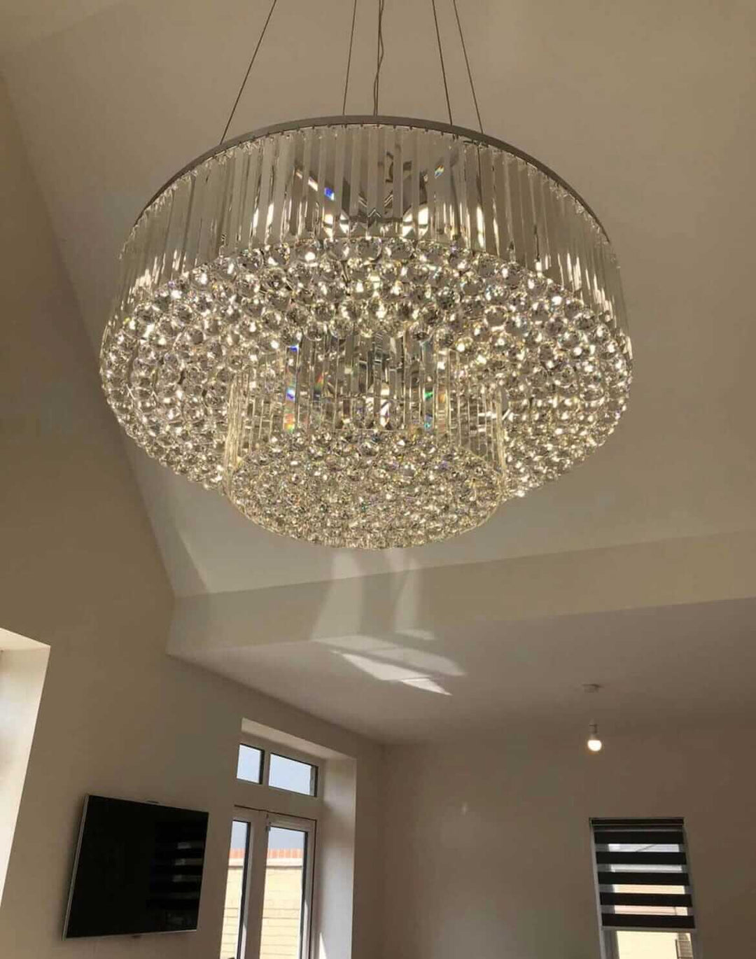 Elegant dual crystal chandelier with shimmering light reflections in modern interior.