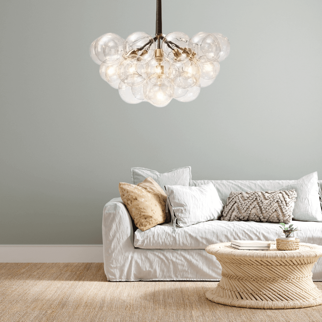 Bubble chandelier with spherical glass orbs hanging over a cozy sofa in a stylish living room setting.