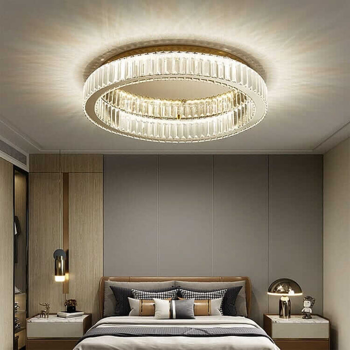 Elegant round chandelier with crystal accents in a modern bedroom, creating a warm and luxurious ambiance.