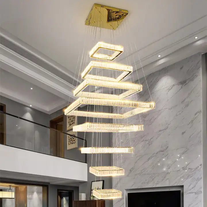 Modern LED staircase chandelier with sleek square design and gold accents, illuminating a stylish foyer.