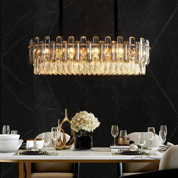 Elegant chandelier illuminating a modern dining table in a luxurious setting.