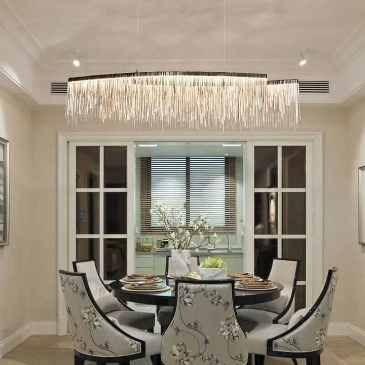 Stylish linear chandelier above an elegant dining table, enhancing the room's ambiance with a warm glow.