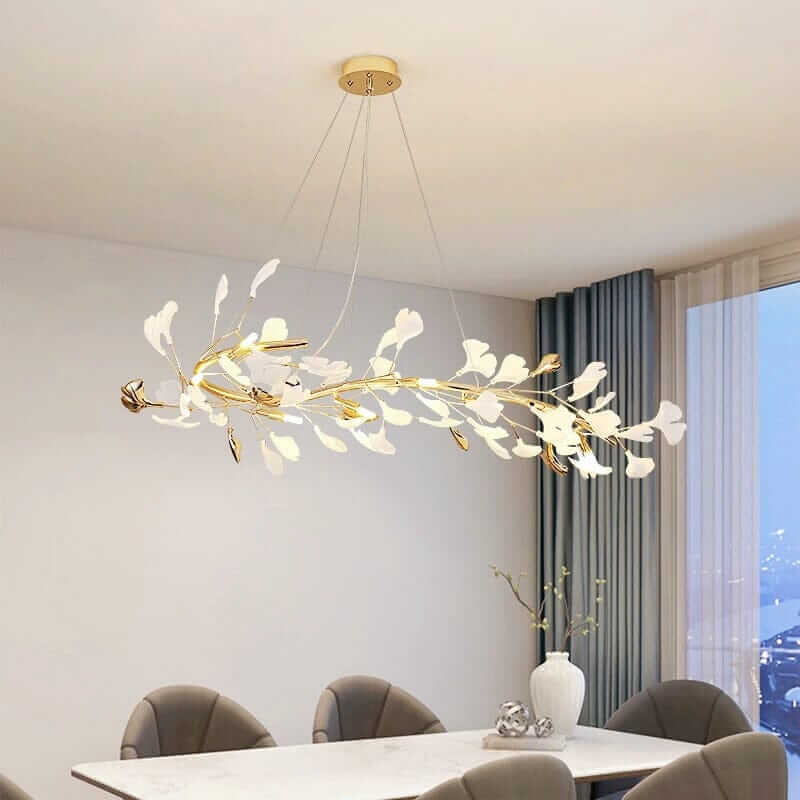 Floral chandelier with white petals and gold accents illuminating a modern dining room.