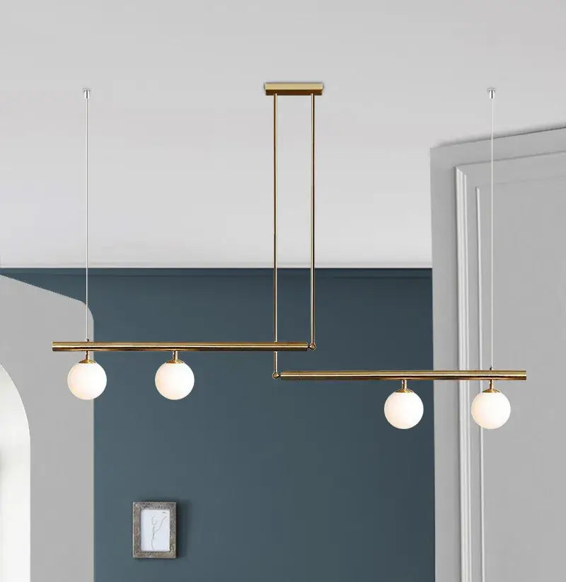 Black and gold modern chandelier with three frosted globes, perfect for kitchen islands.