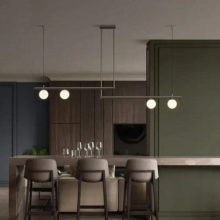 Modern black and gold chandelier above a kitchen island with cozy lighting and contemporary decor.