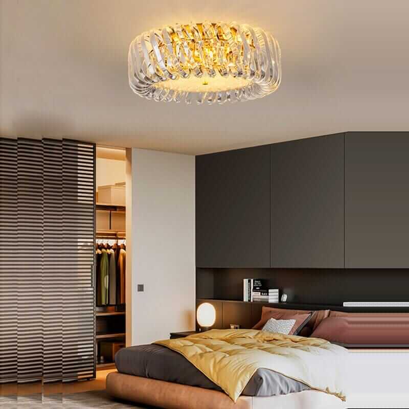 Modern entryway chandelier with a gold finish, illuminating a stylish bedroom with elegant decor.