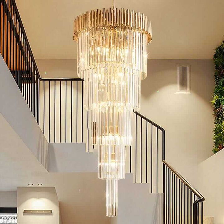 Modern gold chandelier with glass crystals, illuminating a staircase in an elegant interior.