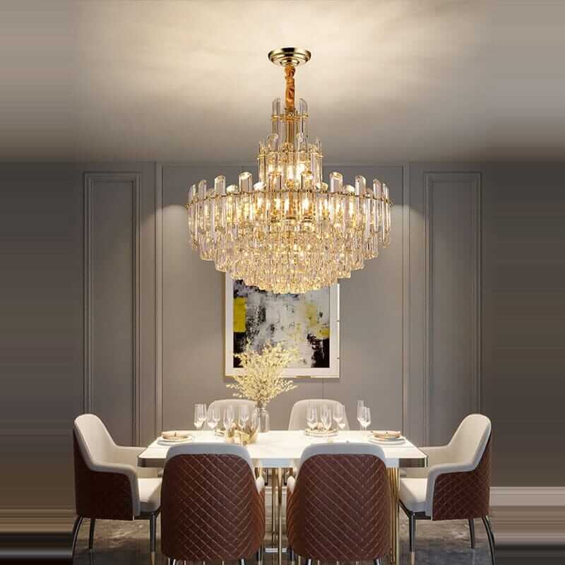 Elegant foyer chandelier lighting up a modern dining room, enhancing ambiance with its gold-plated polished brass design.