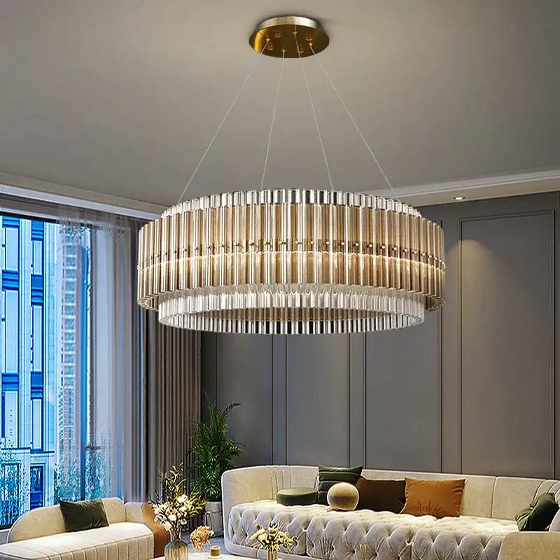 Elegant round hanging gold chandelier with crystal accents illuminating a modern living room.