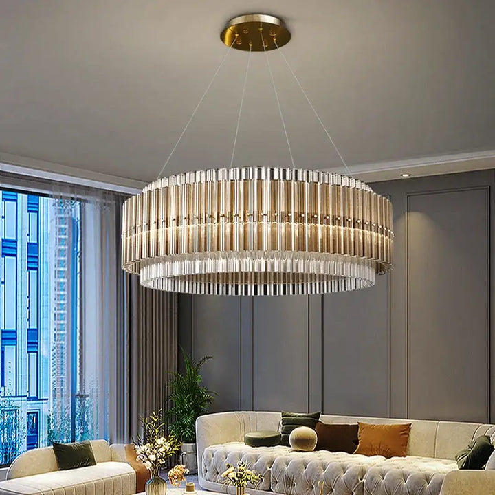 Elegant round hanging gold chandelier with crystal accents illuminating a modern living room.