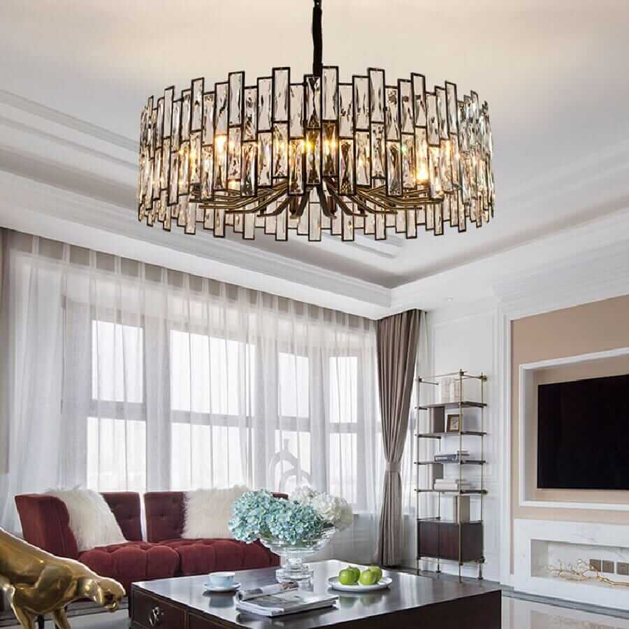 Modern LED chandelier with crystal elements illuminating a stylish living room with elegant decor.