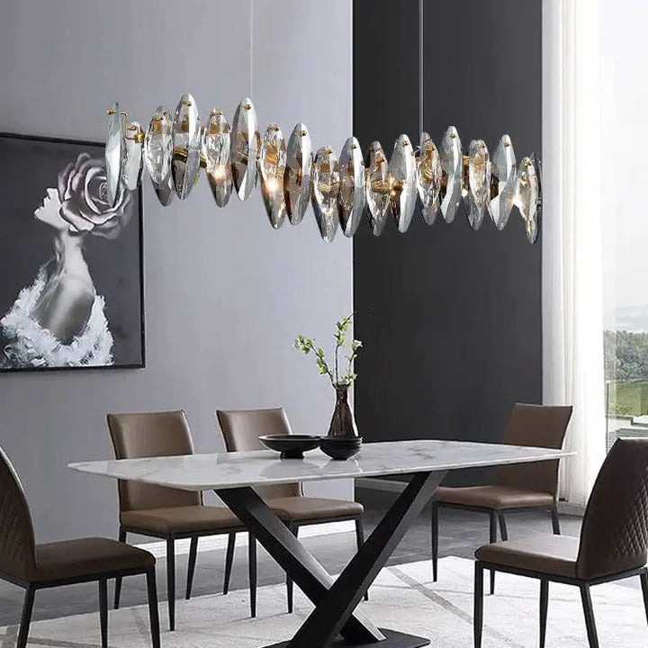 Long restaurant crystal chandelier illuminating a modern dining room with stylish furniture and elegant decor.