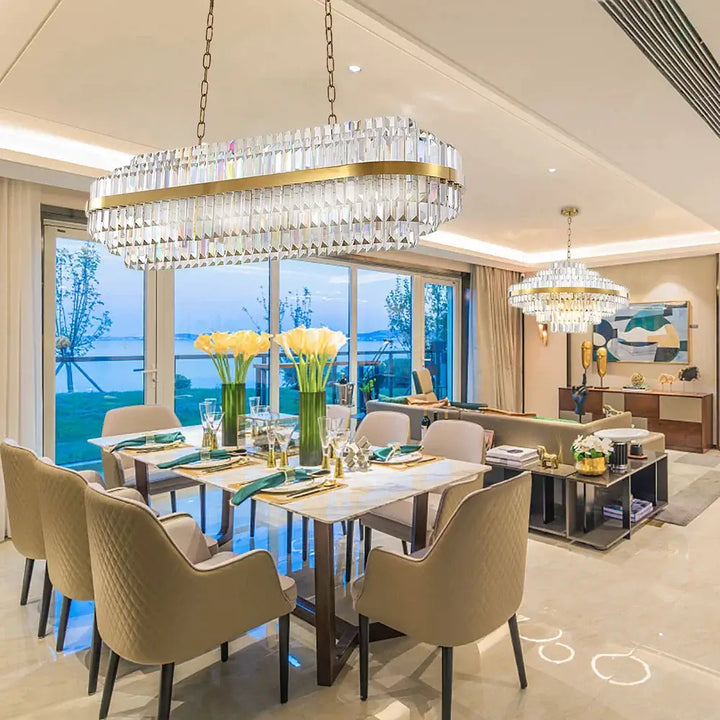 Elegant dining room featuring a stunning gold chandelier, modern furniture, and beautiful views.