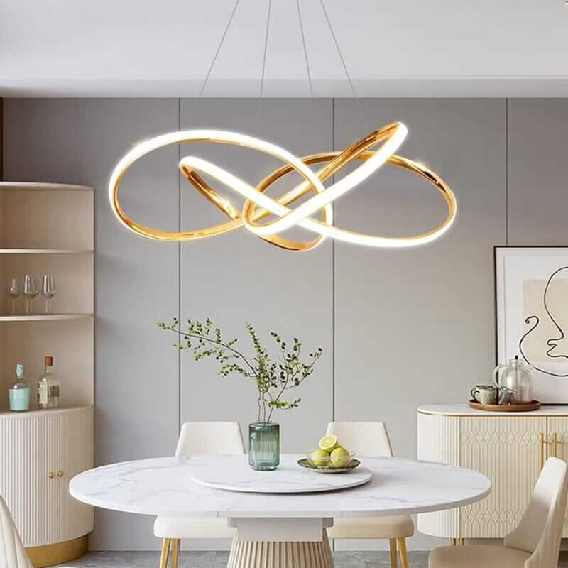 Gold chandelier with integrated LED lights over a modern dining table in a stylish kitchen.