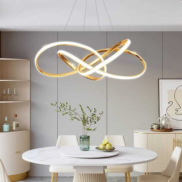 Gold chandelier with integrated LED lights over a modern dining table in a stylish kitchen.
