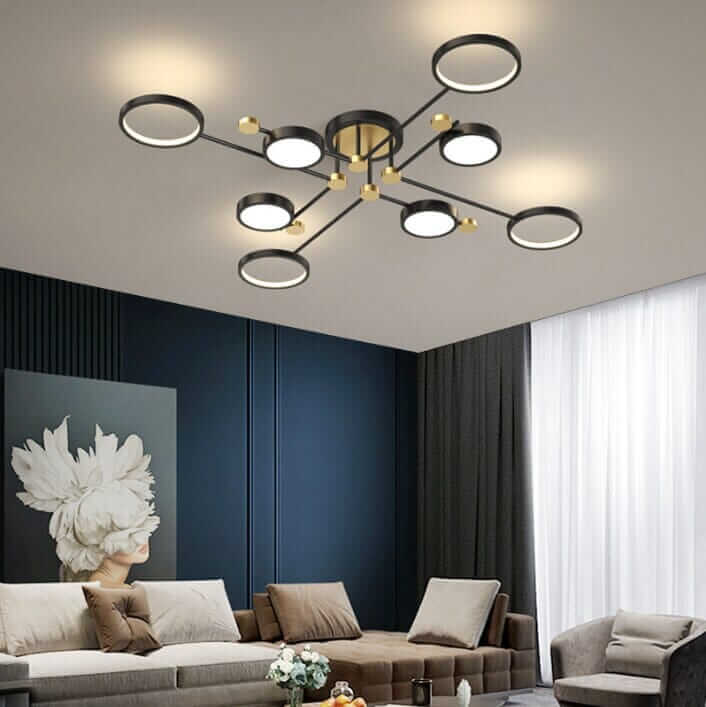 Stylish black and gold chandelier illuminating a cozy living room with modern decor.