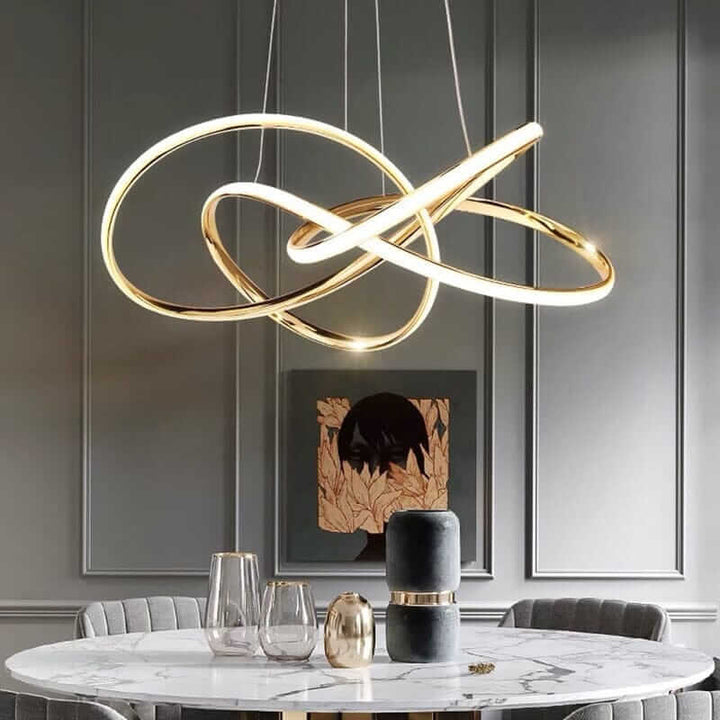 Contemporary gold chandelier with sleek loops illuminating an elegant dining area.