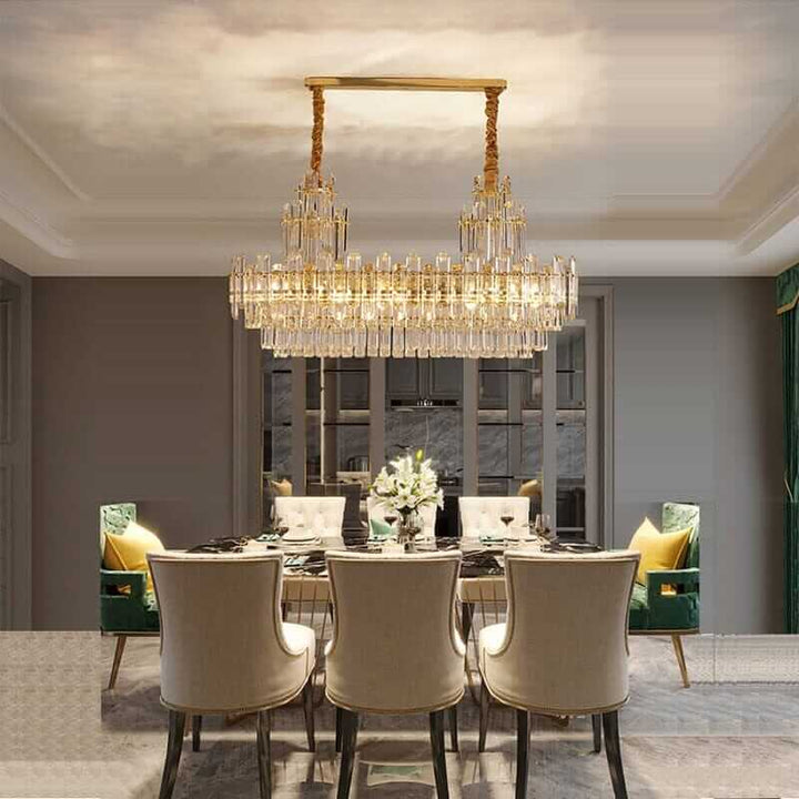 Elegant foyer chandelier in gold-plated polished brass illuminating a stylish dining area with modern decor.