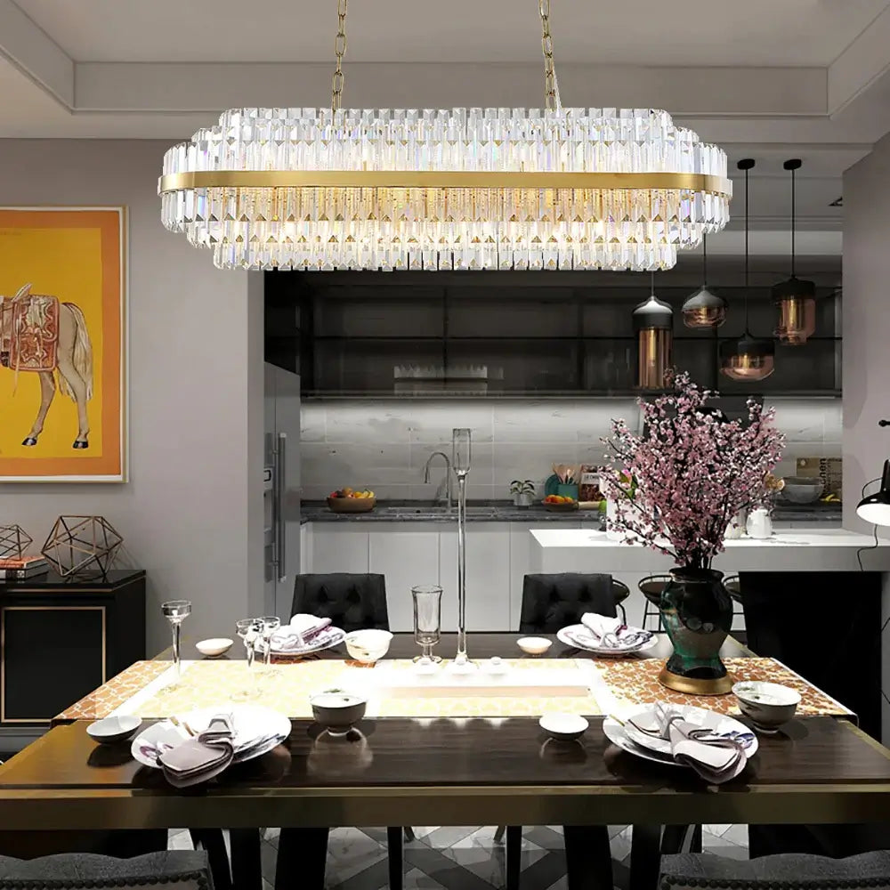 Gold chandelier illuminating a modern dining room with elegant decor and a warm ambiance.