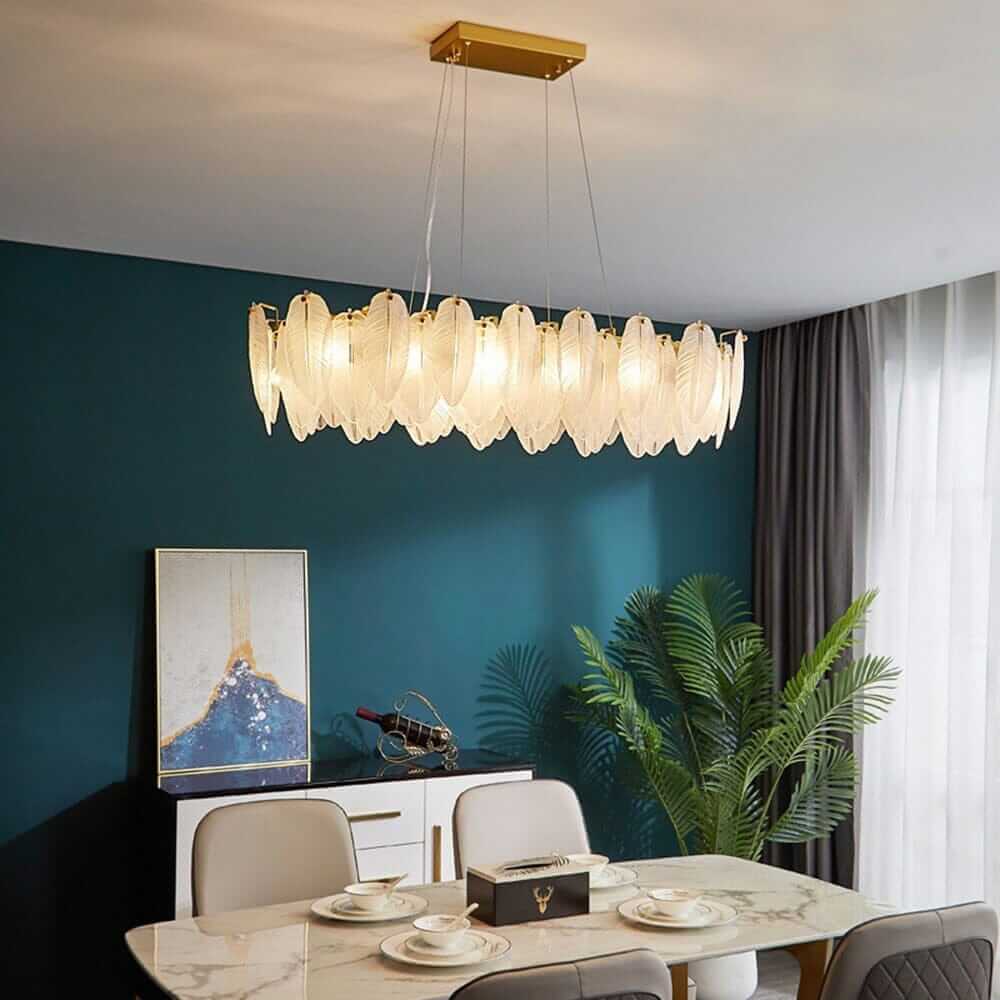 Stylish dining room featuring a contemporary chandelier with leaf-like design and warm lighting over a marble table.