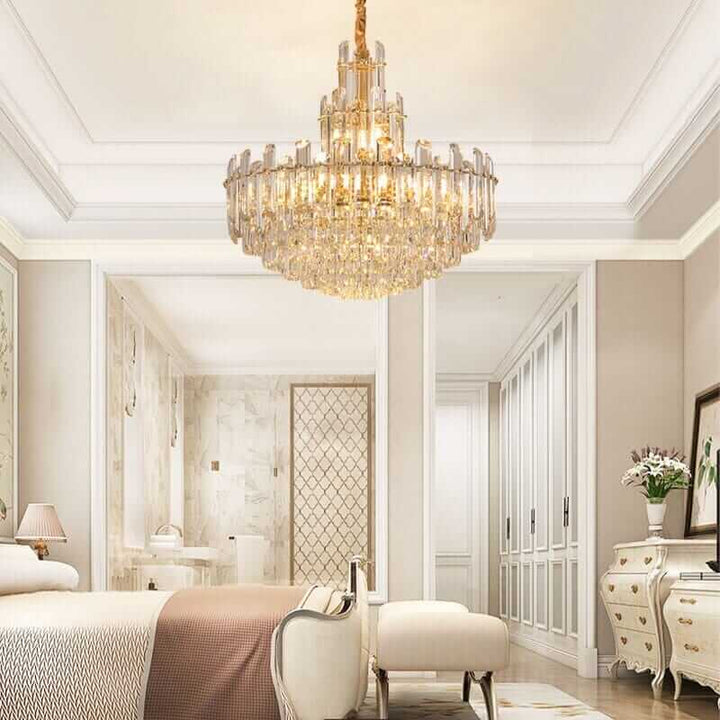 Elegant foyer chandelier illuminating a stylish bedroom with gold-plated polished brass and crystal accents.