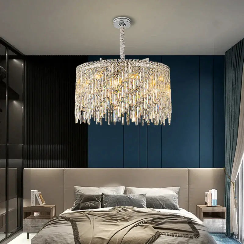 Elegant round chandelier illuminating a modern bedroom with a cozy bed and stylish decor.