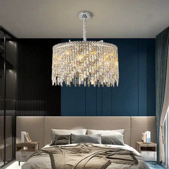 Elegant round chandelier illuminating a modern bedroom with a cozy bed and stylish decor.