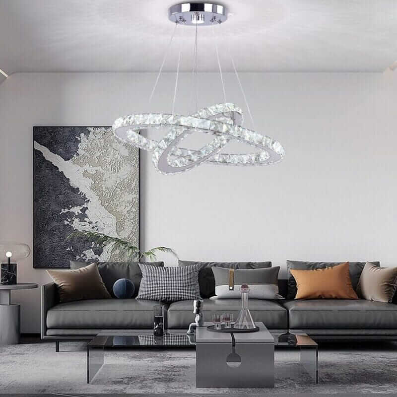 Modern foyer chandelier illuminating a stylish living room with elegant furniture and décor.