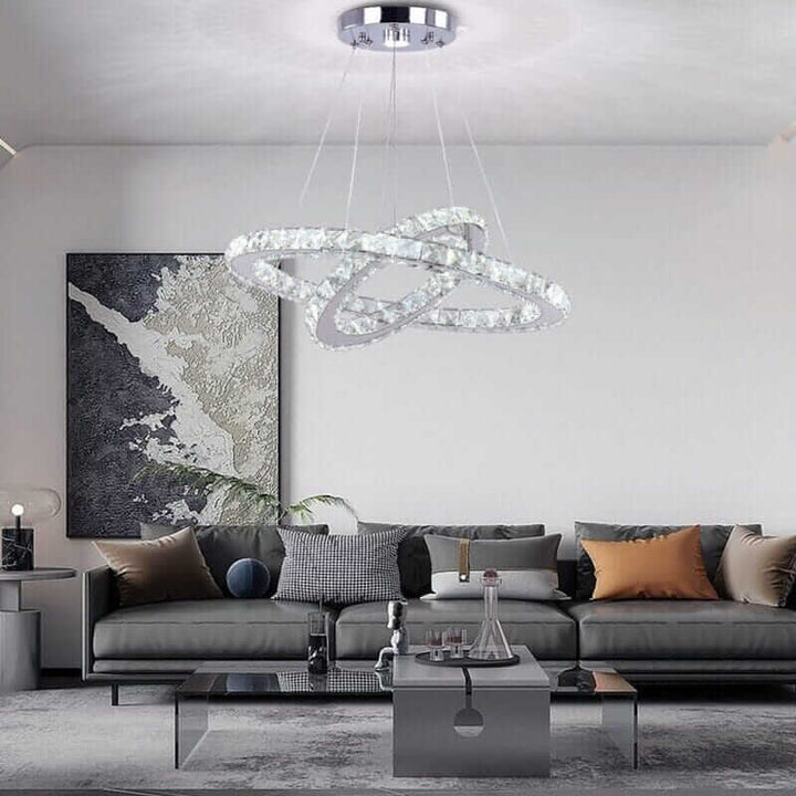 Modern foyer chandelier illuminating a stylish living room with elegant furniture and décor.