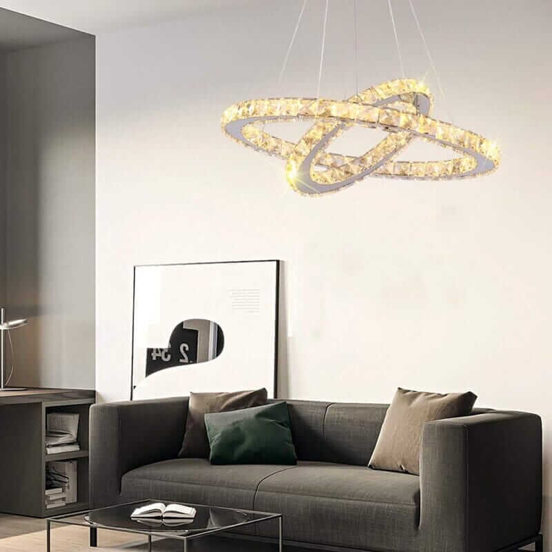 Modern foyer chandelier with intertwined rings illuminating a stylish living room.