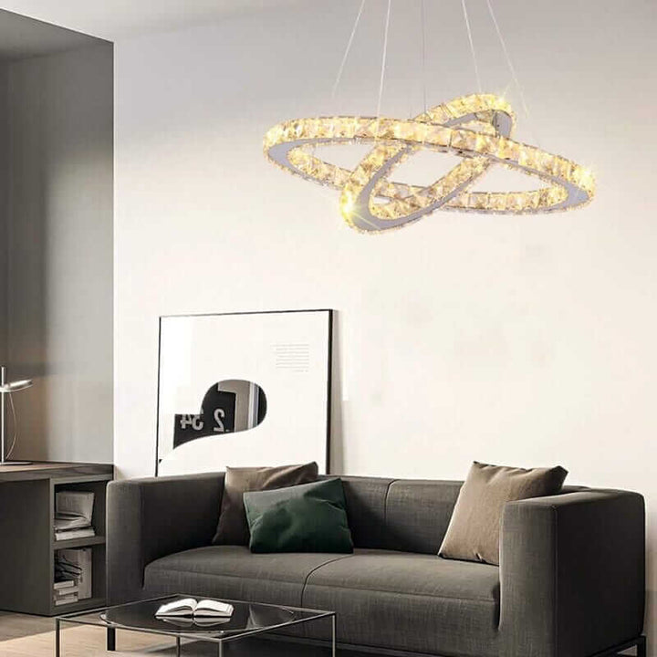 Modern foyer chandelier with intertwined rings illuminating a stylish living room.