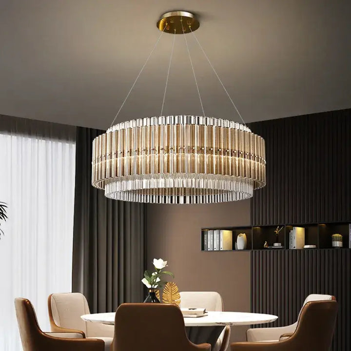 Elegant gold chandelier with crystal accents above a modern dining table, enhancing the room's sophistication and ambiance.