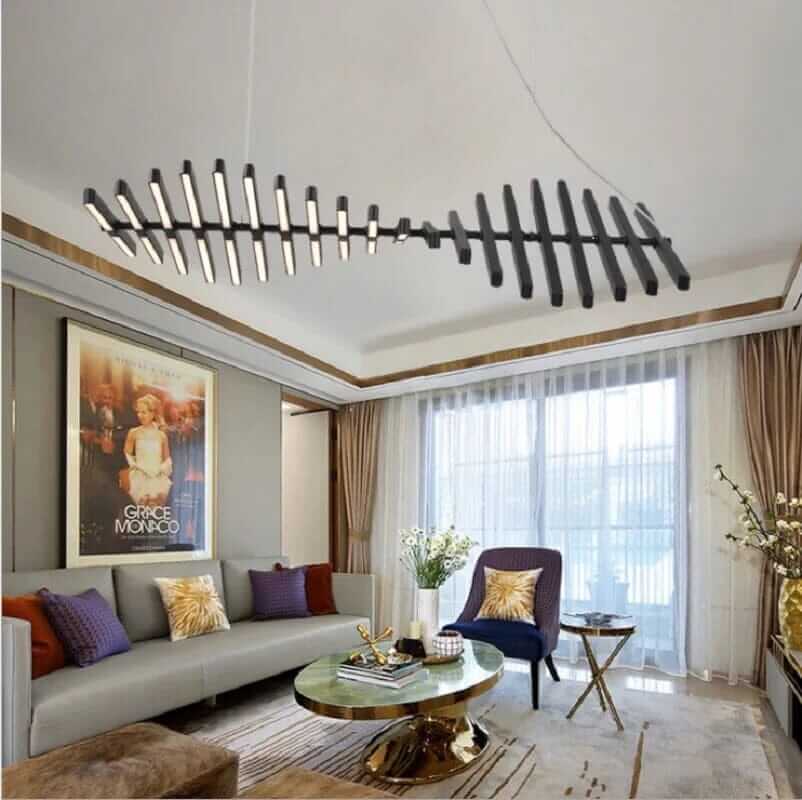 Modern black chandelier resembling a fishbone, illuminating a stylish living room with contemporary decor.