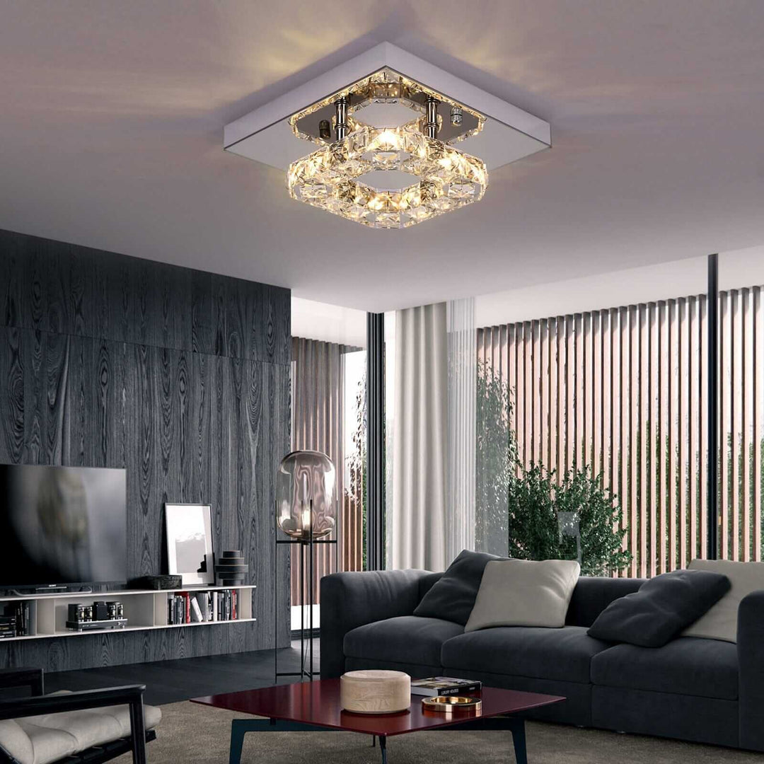 Small crystal chandelier illuminating a modern living room, showcasing a blend of minimalism and elegance.
