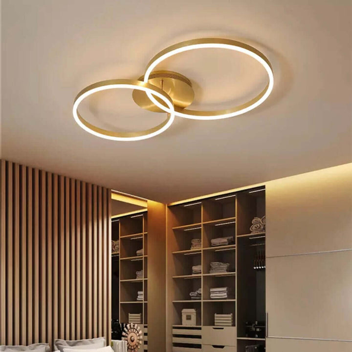 Modern LED chandelier with dual circular rings adding elegance to a stylish bedroom interior.