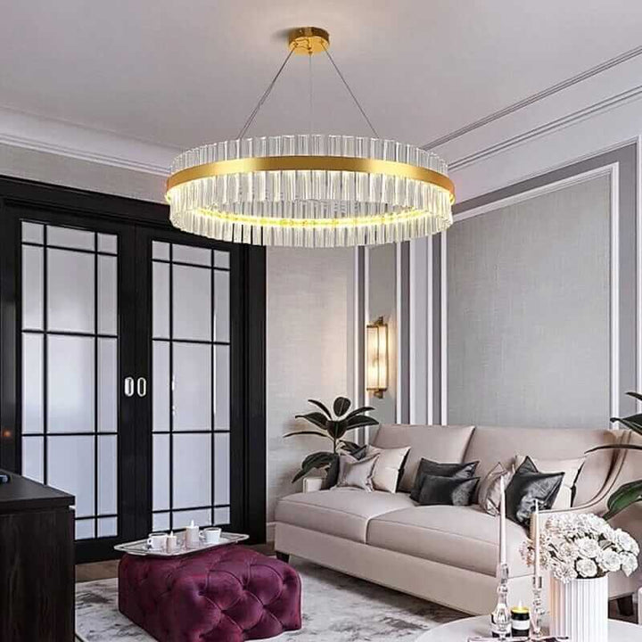 Gold crystal chandelier illuminating a stylish living room with modern decor and elegant finishes.