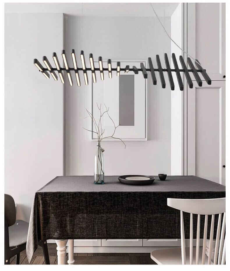 Modern black chandelier resembling a fishbone, illuminating a stylish dining space with minimalist decor.