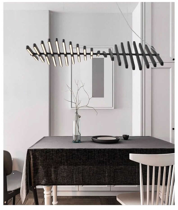 Modern black chandelier resembling a fishbone, illuminating a stylish dining space with minimalist decor.