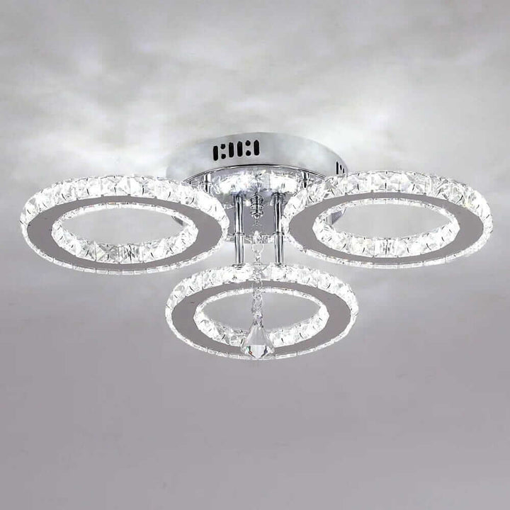 Small crystal chandelier with three circular tiers, adding elegance and glamour to any home decor.