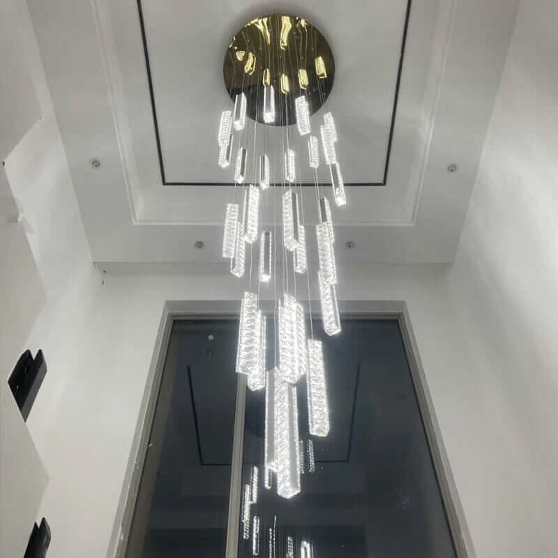 Modern crystal chandelier hanging elegantly from a sleek ceiling, illuminating a spacious staircase.