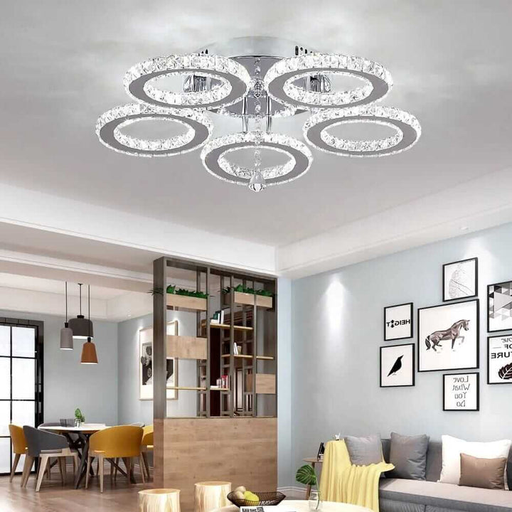 Small crystal chandelier with circular tiers, adds elegance and glamour to modern home decor.