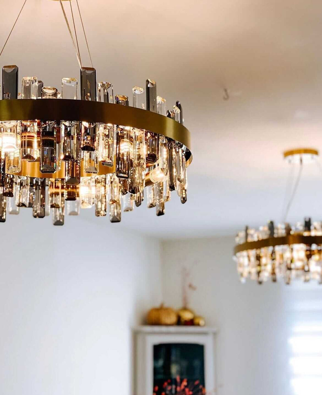 Gold crystal chandelier with elegant design and multiple arms, illuminating a stylish room.