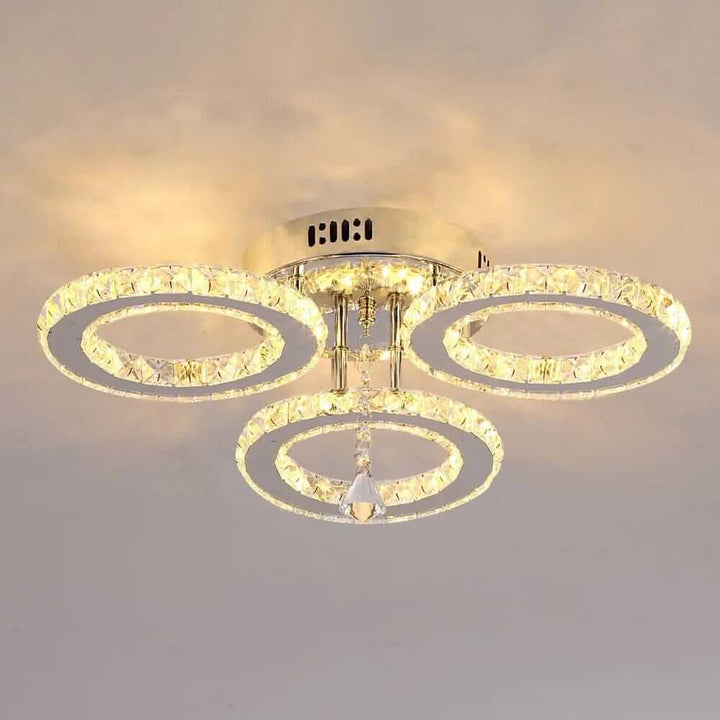 Small crystal chandelier with three tiered rings, adding elegance and glamour to any home decor.