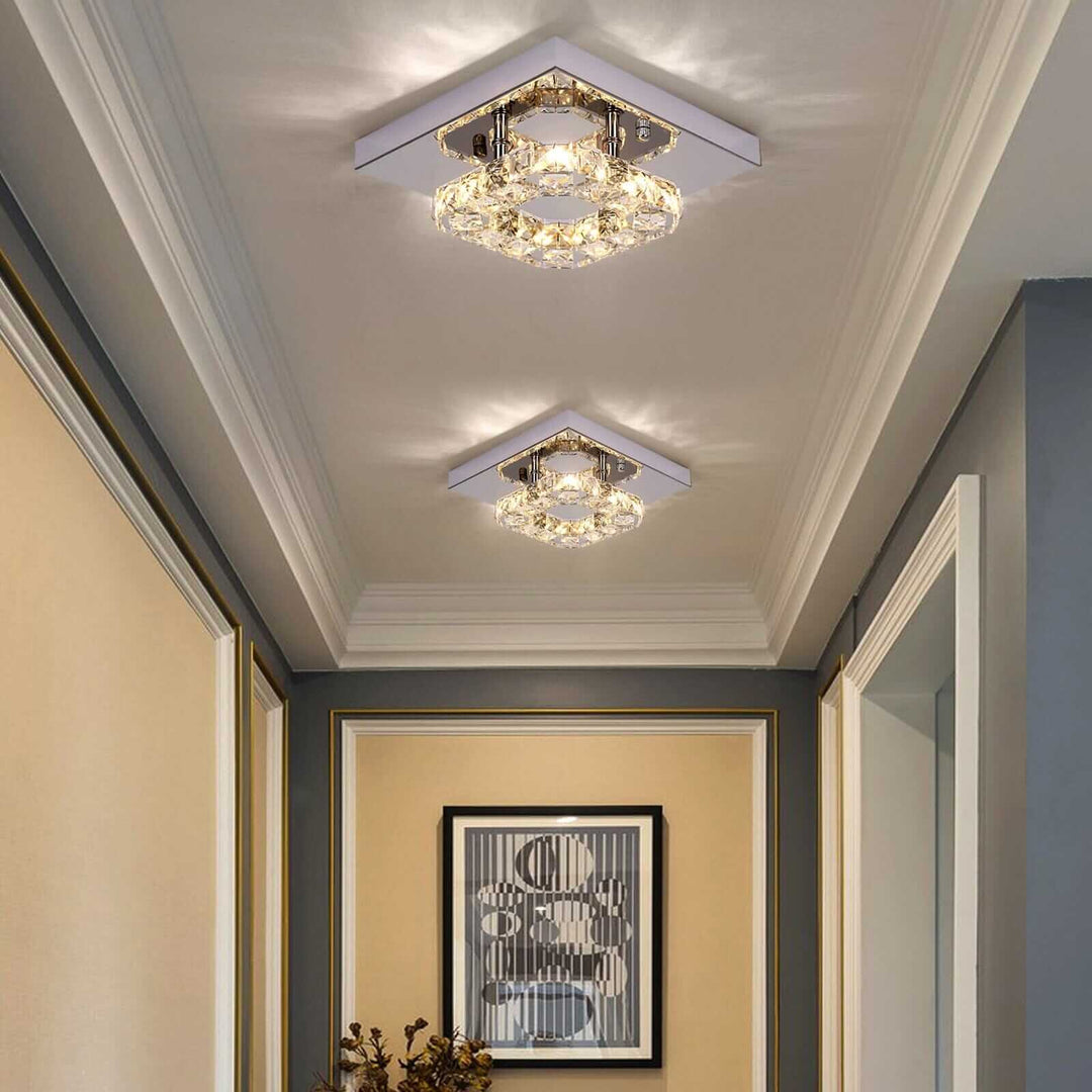 Small crystal chandeliers illuminating a stylish hallway, blending modern minimalism with classic elegance.